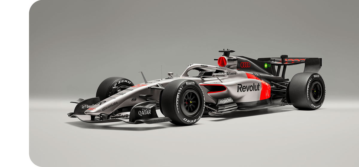 Das Formel-1-Rennfahrzeug Audi R26 vor grauem Studiohintergrund in Dreiviertel-Frontansicht.